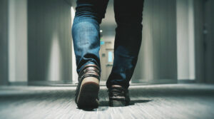 Närbild på ett par ben som går genom en korridor
